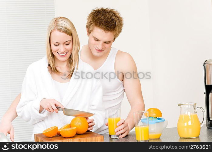 Breakfast happy couple make orange juice in morning kitchen