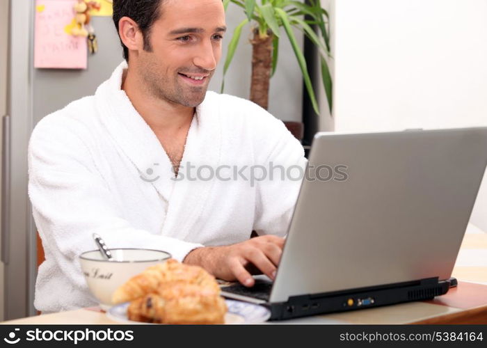 Breakfast in bathrobe with computer