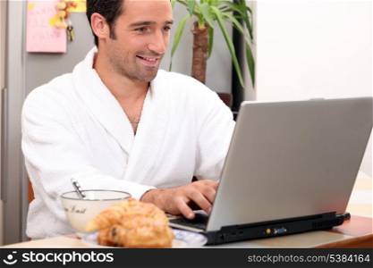 Breakfast in bathrobe with computer