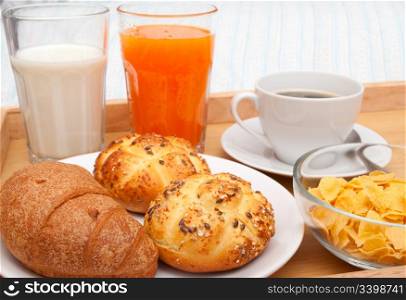 Breakfast in Bed - Closeup of Corn Flakes, Coffee, Croissant, Orange Juice, Coffee, Milk and Rolls on Bed Blanket