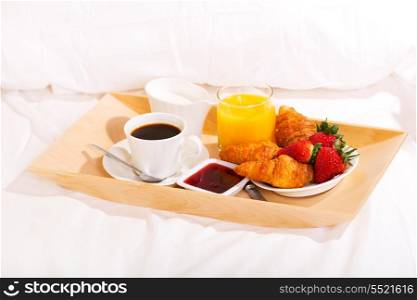 breakfast in bed with coffee, croissants and juice