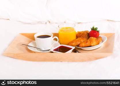 breakfast in bed with coffee, croissants and juice