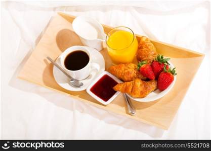 breakfast in bed with coffee, croissants and juice