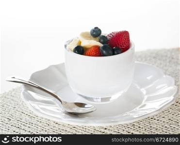 Breakfast of blueberries, strawberries with banana in glass bowl