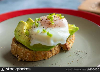 Breakfast of bread toast with avocado and poached egg