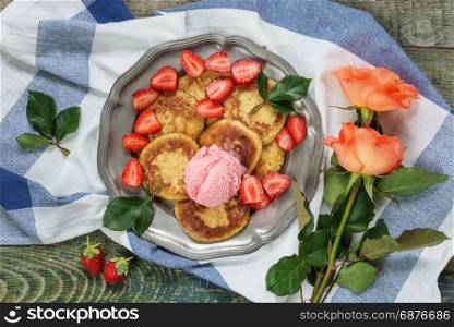 Breakfast of pancakes with ice cream and ripe berries of strawberry, top view