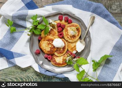 Breakfast of pancakes with sour cream and berries ripe raspberry, top view