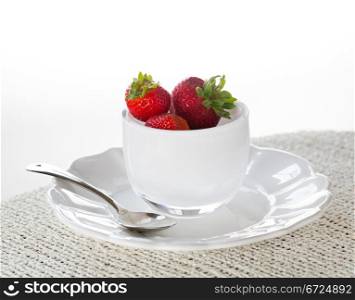 Breakfast of strawberries in glass bowl on white plate