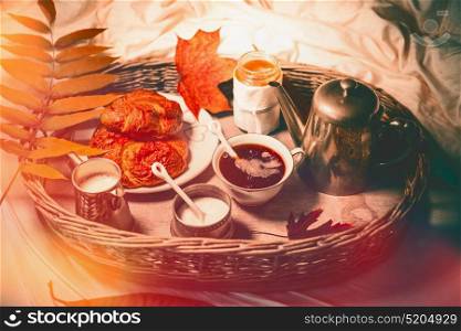 Breakfast on tray in bed. Autumn early morning breakfast with coffee and pastries croissants