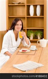 Breakfast orange juice and toast happy woman in home bathrobe