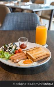 Breakfast sausage set with fried egg and orange juice. Breakfast set