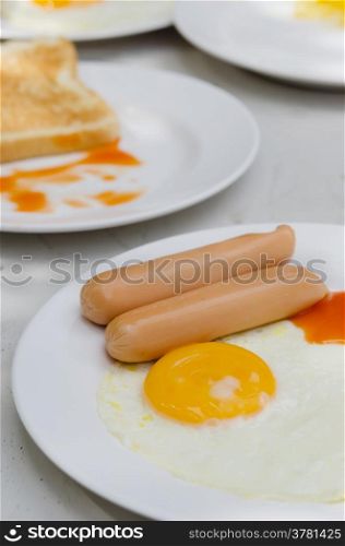 breakfast . sausage with sauce and fried egg on a plate