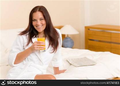 Breakfast - Smiling woman with fresh orange juice in white bedroom