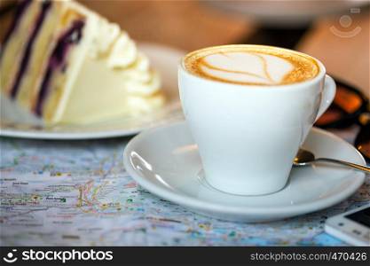 Breakfast traveler - cup of coffee, cake and map