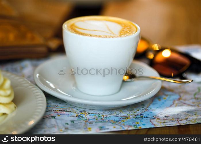 Breakfast traveler - cup of coffee, cake and map