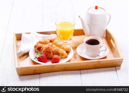 Breakfast. Tray with cup of coffee and croissants.