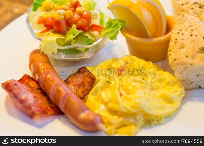 Breakfast with bacon, egg, sausage, salad, and focaccia bread