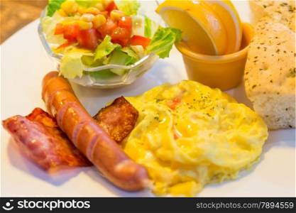 Breakfast with bacon, egg, sausage, salad, and focaccia bread