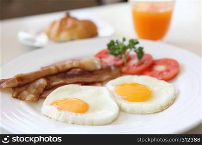 Breakfast with bacon , fried egg and orange juice