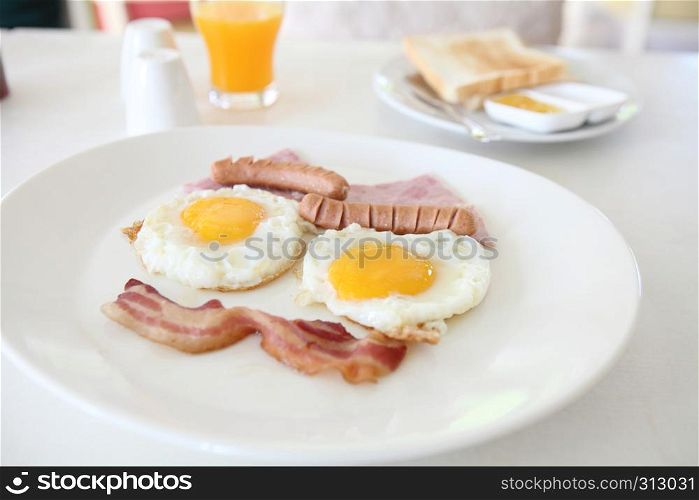 Breakfast with bacon , fried egg and orange juice