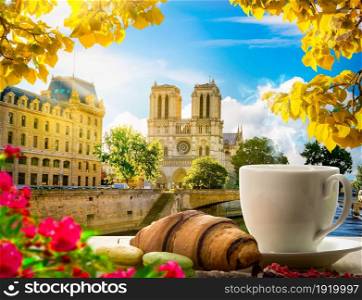 Breakfast with bakery and coffee on table near Notre Dame in Paris, France. Coffee and Notre Dame