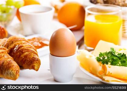 breakfast with boiled egg, croissants and juice
