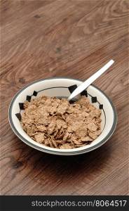 Breakfast with cereal in a bowl isolated against a wooden background