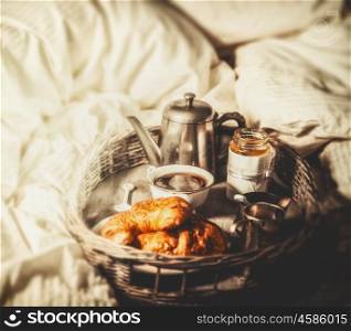 Breakfast with coffee and croissants in bed , selective focus