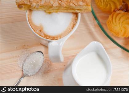 breakfast with coffee and fresh baked pastry over a natural pine wood table
