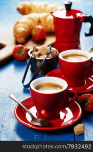 Breakfast with coffee, croissants and berries. Blue background