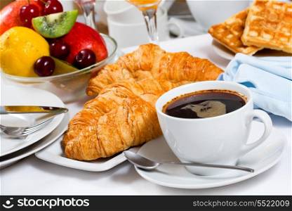 breakfast with coffee, croissants and fresh fruits