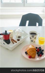 Breakfast with croissant, orange juice and coffee on dinner table. Breakfast with cereles
