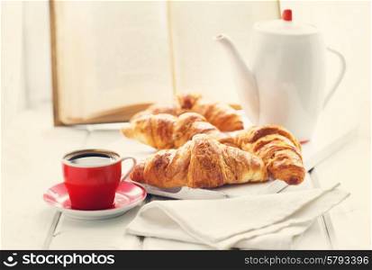 breakfast with croissants and coffee on wooden table