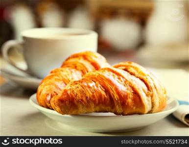 breakfast with croissants, cup of black coffee and newspaper