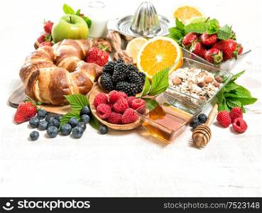 Breakfast with croissants, muesli, berries, fruits, milk. Healthy food concept