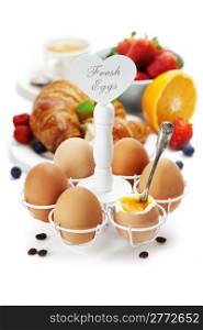 Breakfast with eggs croissants, coffee and orange juice