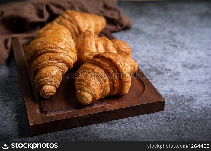 Breakfast with fresh croissants on wooden board