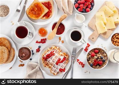 breakfast with granola berry nuts, waffle, toast,  jam, chocolate spread and coffee. Top view