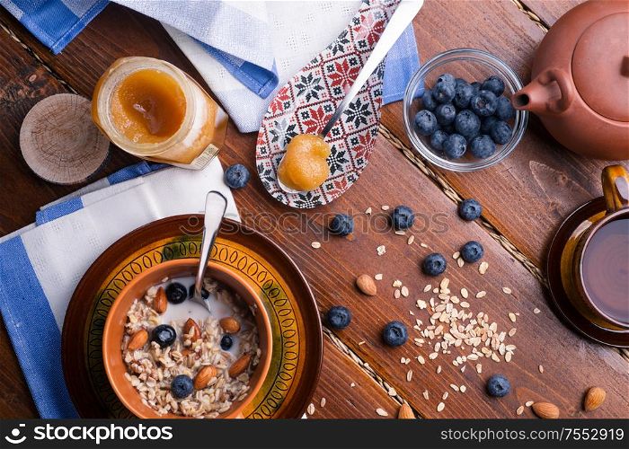 breakfast with oatmeal porridge with blueberries, fruits, almonds and coconut milk. Healthy and tasty vegan breakfast. top view, flat lay.