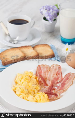 Breakfast with scrambled eggs and crispy bacon