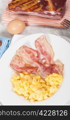 Breakfast with scrambled eggs and crispy bacon