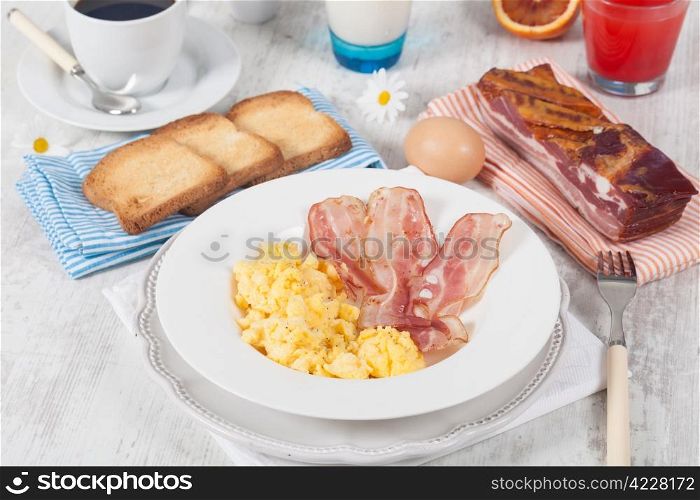 Breakfast with scrambled eggs and crispy bacon