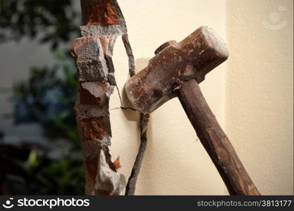 Breaking wall with hammer for renovating house