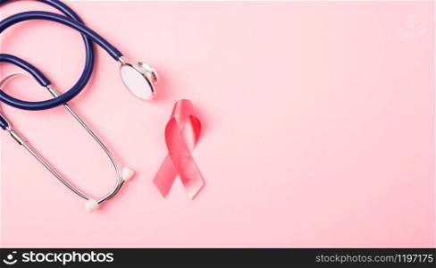 Breast Cancer Awareness Month Health concept, top view flat lay pink ribbon and stethoscope on pink background with copy space for your text