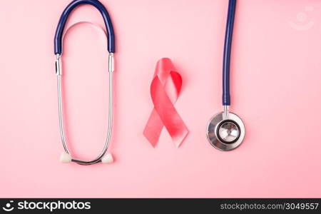 Breast Cancer Awareness Month Health concept, top view flat lay pink ribbon and stethoscope on pink background with copy space for your text