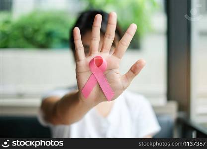Breast Cancer Awareness, Woman hand holding Pink Ribbon for supporting people living and illness. Women Healthcare and World cancer day concept