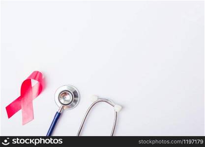 Breast cancer month concept, flat lay top view, pink ribbon and stethoscope on white background with copy space for your text
