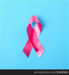 Breast cancer month concept, flat lay top view, pink ribbon on blue background with copy space for your text
