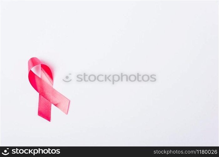 Breast cancer month concept, flat lay top view, pink ribbon on white background with copy space for your text