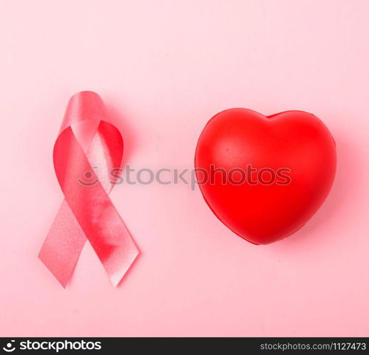 Breast cancer month health concept, flat lay top view, put pink ribbon and Red Heart on pink background with copy space for your text